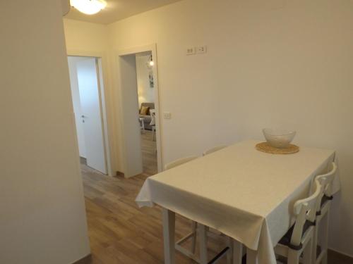 a dining room table with a white table cloth on it at Apartments Villa Elma in Mošćenička Draga