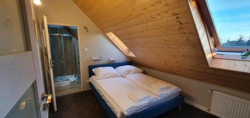 a small bed in a room with a window at Dom w mieście Reszel in Reszel