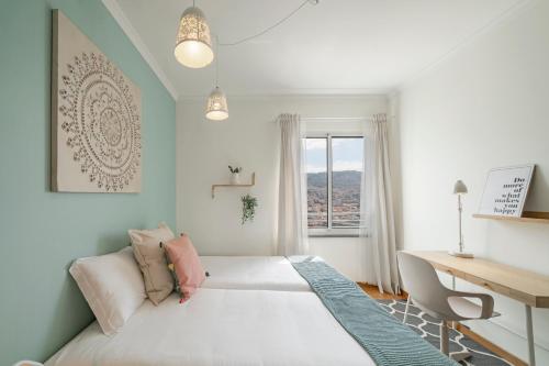 Un dormitorio con una cama y un escritorio y una ventana. en Jasmineiro I by An Island Apart, en Funchal