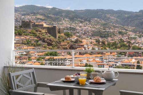 a table with food on a balcony with a view at Jasmineiro I by An Island Apart in Funchal
