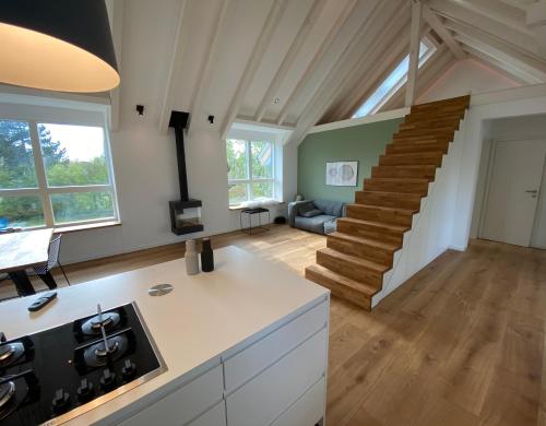 eine Küche mit einer Treppe und ein Wohnzimmer in der Unterkunft “STADT-LAND-SCHEUNE” - luxuriös in alten Gemäuern in Braunschweig
