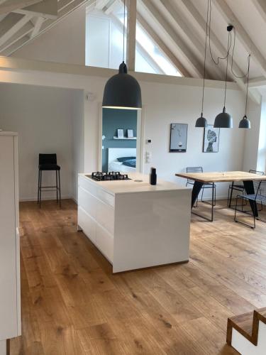 a kitchen with a white counter and a table at “STADT-LAND-SCHEUNE” - luxuriös in alten Gemäuern in Braunschweig