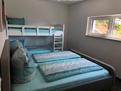 a bedroom with two bunk beds and a window at Moderne Ferienwohnung mit Terrasse und Garten in Haldenwang