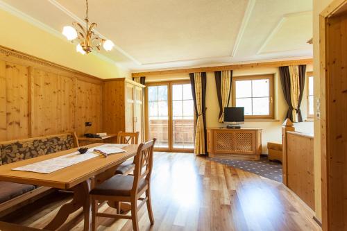 a dining room with a table and a tv at Rimlhof by A CASA in Längenfeld