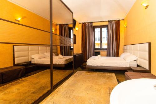 Pokój hotelowy z 2 łóżkami i lustrem w obiekcie Borgo San Paolo Stylish Apt with Jacuzzi w Turynie