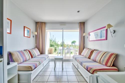 un salon avec deux canapés et une fenêtre dans l'établissement Appartement avec jardin partagé pour 4, à Les Sables-dʼOlonne