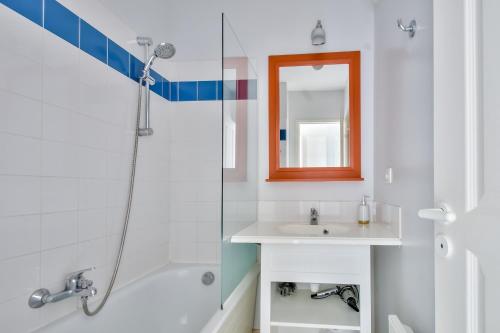 une salle de bain avec une douche, un lavabo et un miroir dans l'établissement Appartement avec jardin partagé pour 4, à Les Sables-dʼOlonne