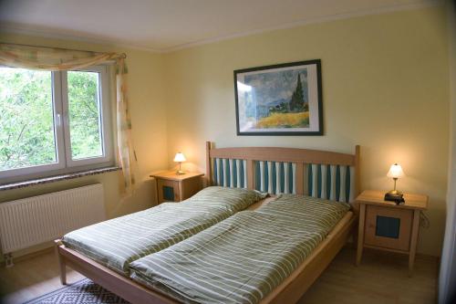a bedroom with a bed and two lamps on tables at F-1042 Ferienwohnung Enna in Ostseebad Sellin