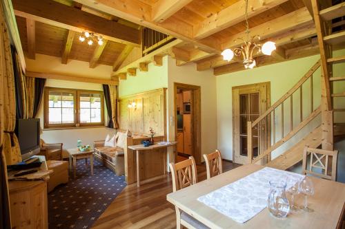 a kitchen and living room with wooden ceilings and a table at Rimlhof by A CASA in Längenfeld