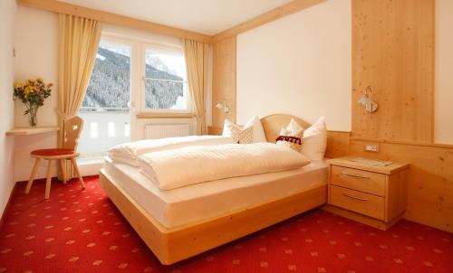 sypialnia z łóżkiem i oknem w obiekcie Apartments Antines w mieście Selva di Val Gardena
