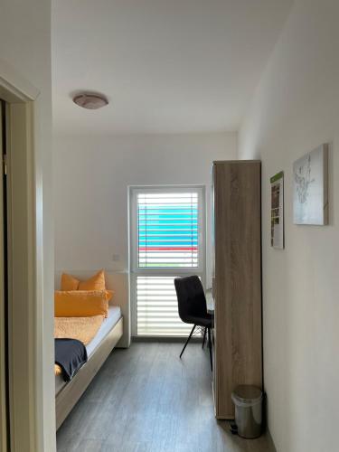 Schlafzimmer mit einem Bett, einem Schreibtisch und einem Fenster in der Unterkunft TWT Motel in Triptis