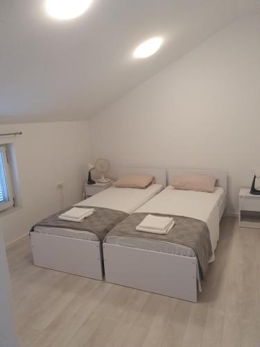 een slaapkamer met een bed met twee handdoeken erop bij Franko & Šimun Apartment in Šibenik