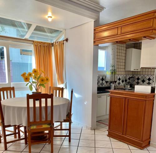 a kitchen with a table and some chairs and a table and a kitchen at Residencial Nápole in Torres