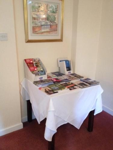 a table with a white table cloth and books on it at Ashley Hotel in Cambridge