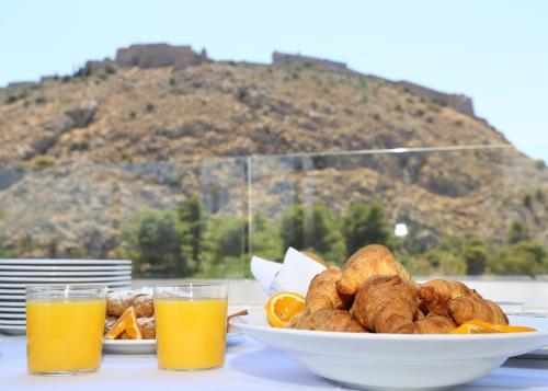 a table with a bowl of food and two glasses of orange juice at Liberty of Nafplio in Nafplio