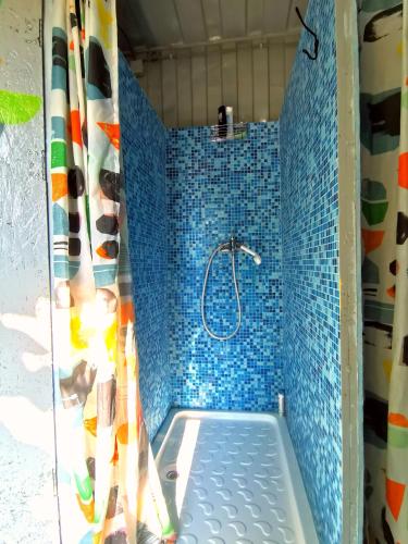 a bathroom with a shower with blue tiles at Oz 2mai in 2 Mai