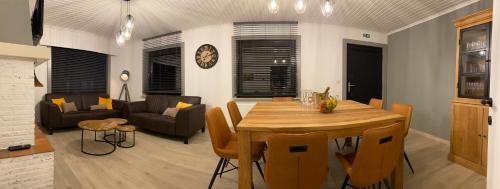 a dining room and living room with a table and chairs at vakantiehuis zoetendaal in Reningelst