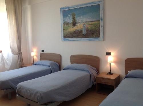 Zimmer mit 3 Betten und Wandgemälde in der Unterkunft Ospitalità San Tommaso d'Aquino in Bologna