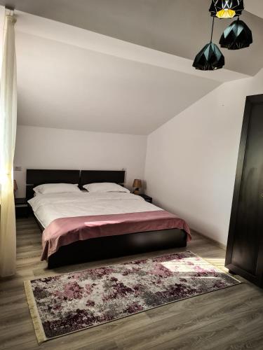 a bedroom with a large bed and a rug at Pensiunea Lavanda, Piatra-Neamț in Piatra Neamţ