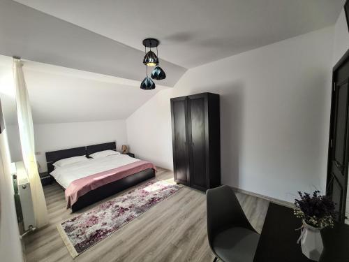 a bedroom with a bed and a table and chair at Pensiunea Lavanda, Piatra-Neamț in Piatra Neamţ