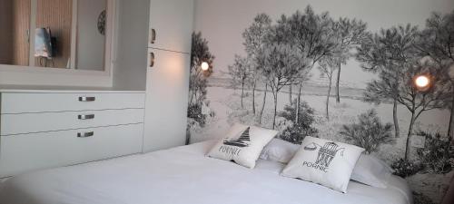a bedroom with a bed with two pillows on it at Gîte Le Plessis Océan à 200m de la mer, parking privé et jardin clos in Pornic