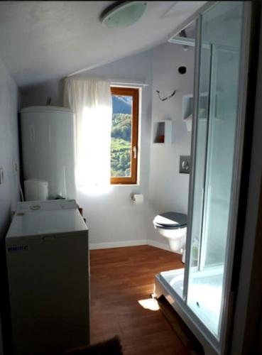 a small bathroom with a toilet and a window at Cocon duplex à la ferme in Boutx