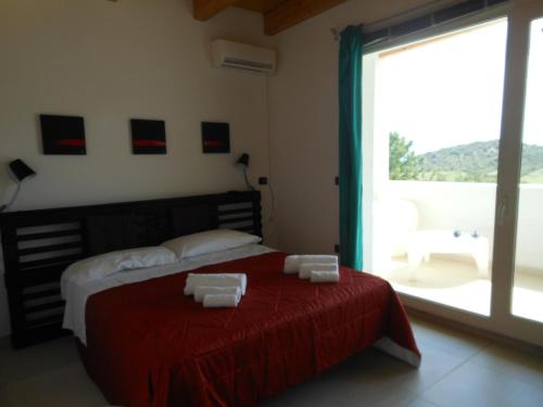 a bedroom with a bed and a large window at Natur Hotel Tanca in Cardedu