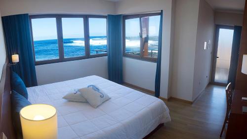 a bedroom with a bed with a view of the ocean at Baia da Barca in Madalena