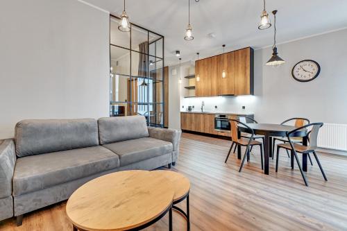 a living room with a couch and a table at Dom & House - Apartments Granaria in Gdańsk
