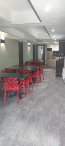 a room with red tables and red benches at Moulin de Parayre in Les Vignes