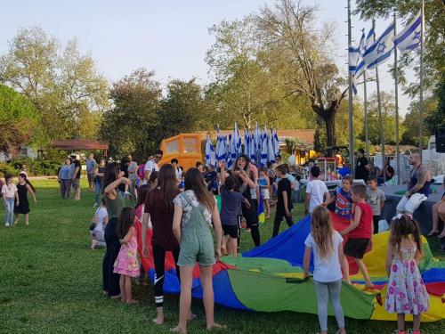 a crowd of people standing in a field with a kite at לארח, זה בטבע שלנו in Kefar Blum