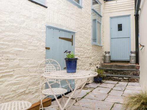 a table and two chairs on a patio with a door at The Old Dairy in Torpoint