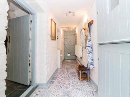 a hallway with a tile floor and white walls at The Old Dairy in Torpoint