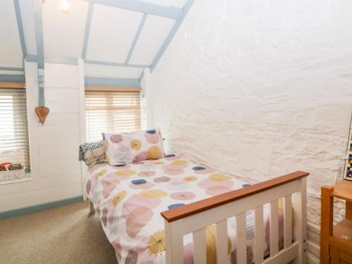 a bedroom with a bed with a crib at The Old Dairy in Torpoint