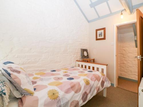 a bedroom with a bed in a room with a ceiling at The Old Dairy in Torpoint