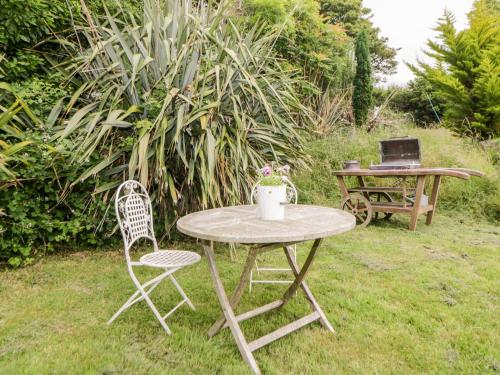 a table and two chairs and a table with a laptop at The Old Dairy in Torpoint