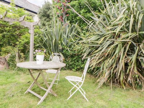 a table and two chairs in a garden at The Old Dairy in Torpoint