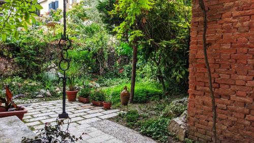 un jardín con macetas y una pared de ladrillo en Tiepolo 3, en Venecia
