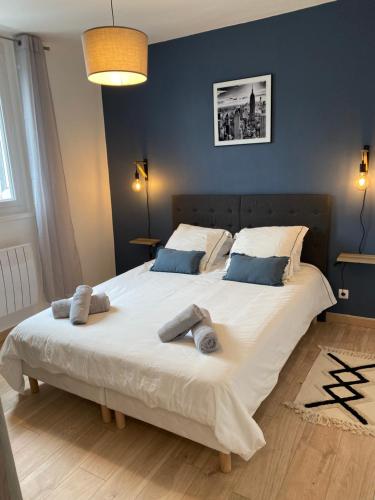 Un dormitorio con una gran cama blanca con dos almohadas. en Family Appart 2, en Le Tréport