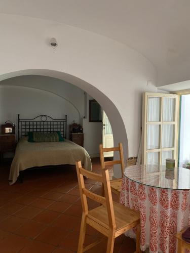 a bedroom with a bed and a table with chairs at Casa do Menino Jesus in Évora