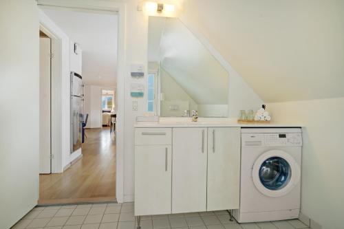 a white laundry room with a washer and dryer at Skagen Harbour Hotel in Skagen
