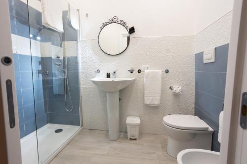 un bagno con lavandino, water e specchio di EXCLUSIVE ROOMS Al Vicoletto a Scalea