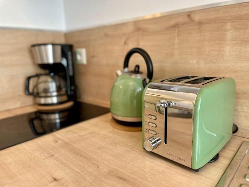 Un grille-pain vert est installé au-dessus d'un comptoir de cuisine. dans l'établissement Le Bohème, à Bayeux