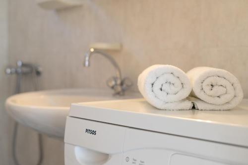 łazienka z ręcznikami na górze pralki w obiekcie Anthia Apartment Sea View w mieście Kato Zakros