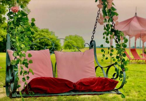 a swing with pillows on it in a park at Hotel Villa Montanarini in Villarotta