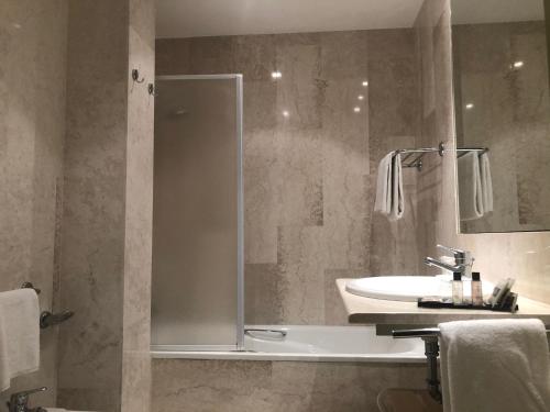 a bathroom with a shower and a sink and a tub at Hotel Villa Montanarini in Villarotta