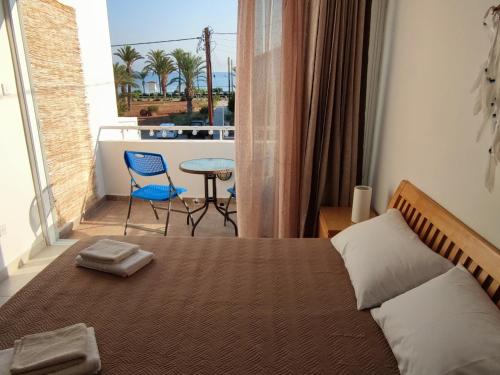 a bedroom with a bed and a table and a balcony at Mediterranean Seaside Authentic Beach House in Polis Chrysochous
