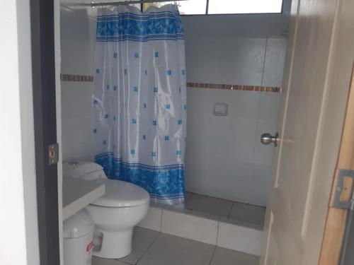 a bathroom with a toilet and a shower curtain at MarAzul, Casa grade familiar en Zorritos in Zorritos