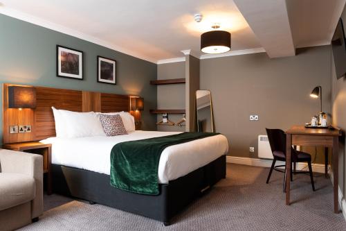 a hotel room with a bed and a desk and a chair at The Oatlands Chaser by Innkeeper's Collection in Weybridge