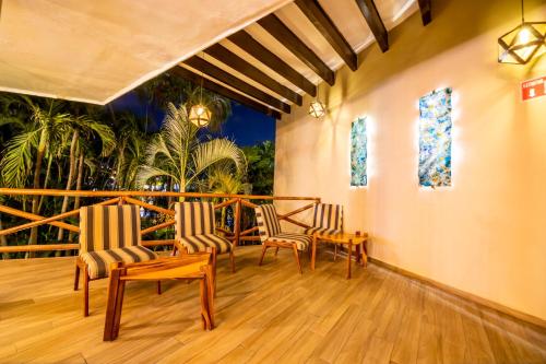 a living room with chairs and a table and windows at Emporio Acapulco in Acapulco
